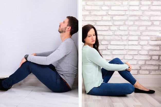 Photo sad couple sitting on floor