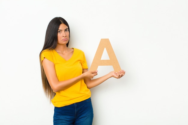 sad, depressed, unhappy, holding the letter A of the alphabet to form a word or a sentence.