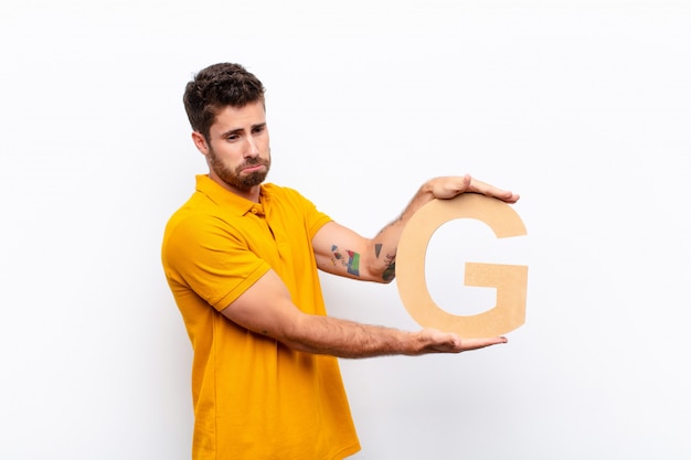 sad, depressed, unhappy, holding the letter G of the alphabet to form a word or a sentence.