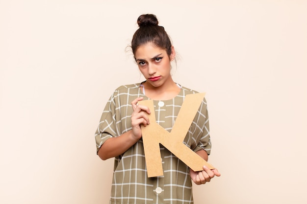 sad, depressed, unhappy, holding the letter K of the alphabet to form a word or a sentence.