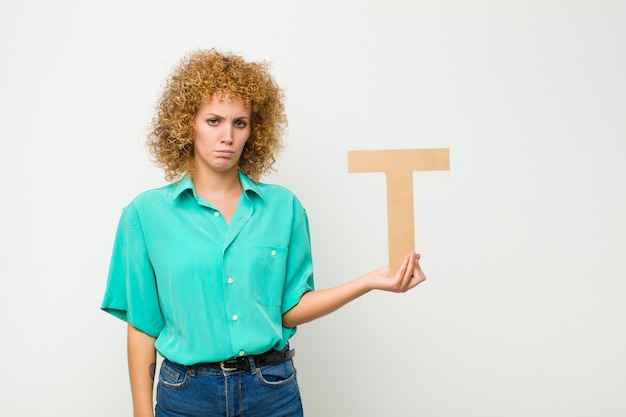 sad, depressed, unhappy, holding the letter T of the alphabet to form a word or a sentence.