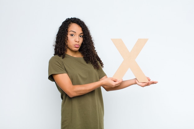 sad, depressed, unhappy, holding the letter X of the alphabet to form a word or a sentence.