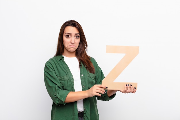 sad, depressed, unhappy, holding the letter Z of the alphabet to form a word or a sentence.
