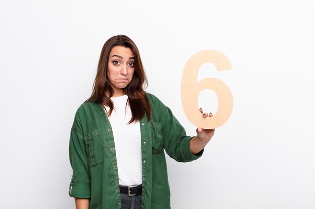 sad, depressed, unhappy, holding a number 6.