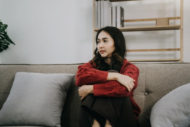 Sad and depressed young female sitting on the sofa sad mood\
feel tired lonely and unhappy concept