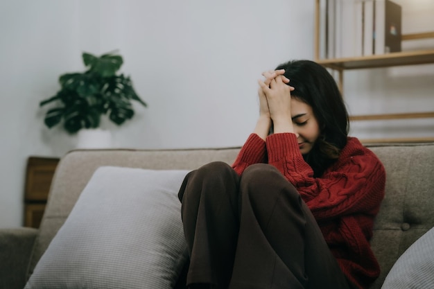 Sad and depressed young female sitting on the sofa sad mood\
feel tired lonely and unhappy concept