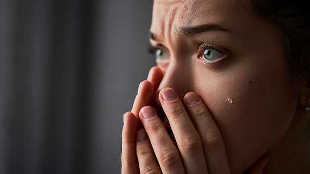 Фото Грустная отчаянная плачущая женщина со сложенными руками и слезами на глазах во время бед