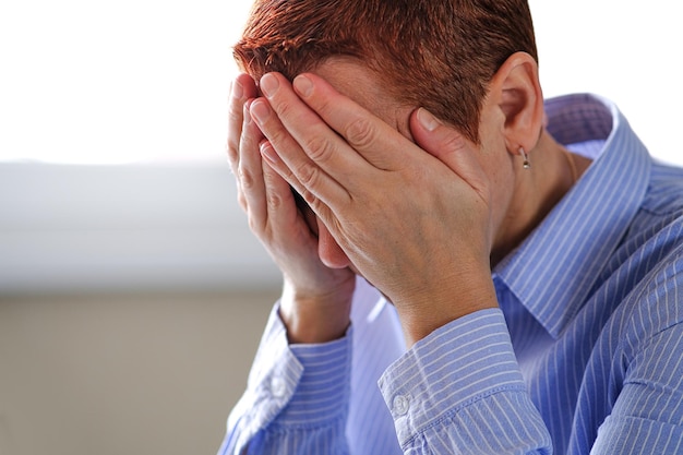 Photo sad desperate grieving crying woman with folded hands and tears eyes during trouble life difficulties depression and emotional problems