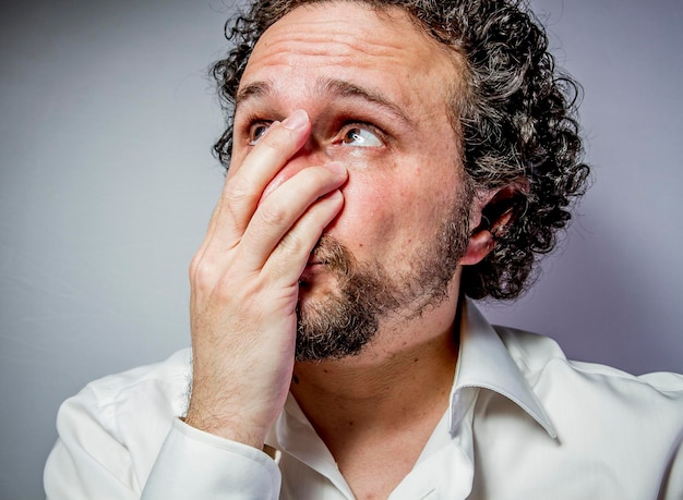 Foto faccina triste, uomo dall'espressione intensa, camicia bianca