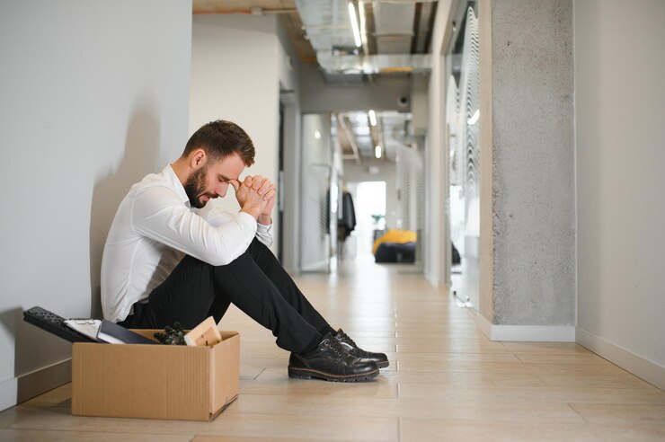 Photo sad fired businessman sitting outside meeting room after being dismissed