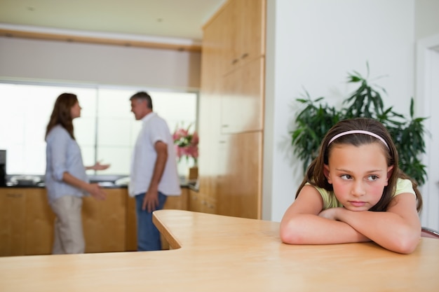 Photo sad girl listening to fighting parents