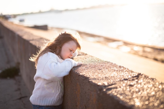 Sad girl with long hairs near river childhood