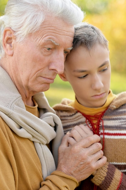 Sad grandfather and grandson hugging