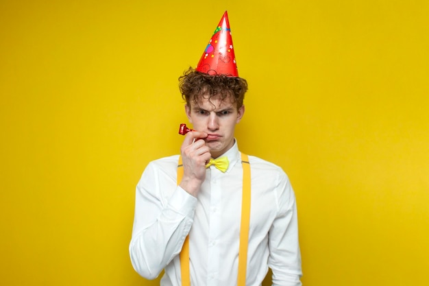 Sad guy in festive outfit and hat is sad unfortunate student in bowtie celebrates birthday alone