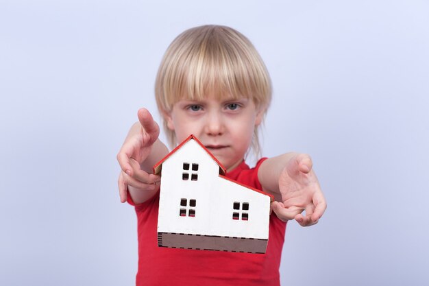 Photo sad kid throws model home. orphanage, orphan, adoption.