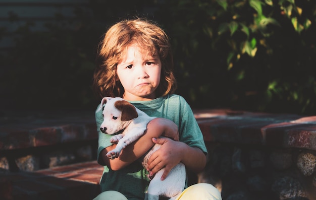 チワワ混合犬と悲しい子供たち子供は愛情を込めて彼のペットの犬を抱きしめます