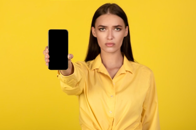 Sad lady holding showing empty smartphone screen