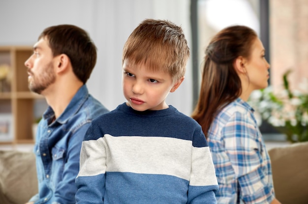 sad little boy with unhappy parents at home