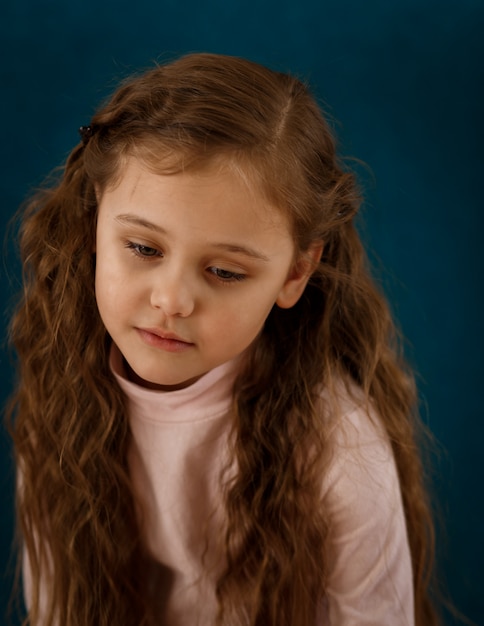 Sad little girl on a blue background