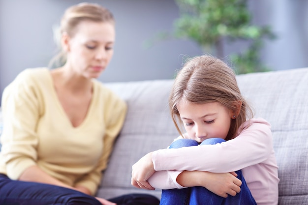 sad little girl and her mom at home