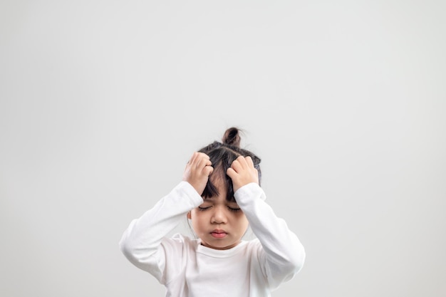 Sad little girl holds his head. little girl feeling sick, having headache.