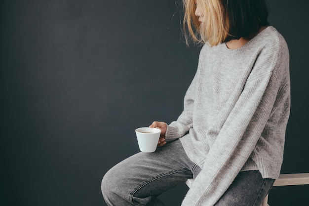 Sad and lonely young woman sitting alone at home