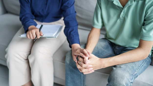sad male sitting on sofa patient discussing mental health issues with psychologist depressed asian man mental health treatment