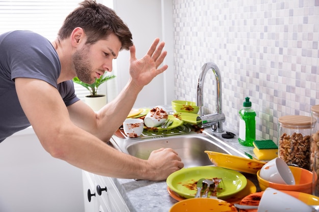 汚れた食器を見て悲しい男