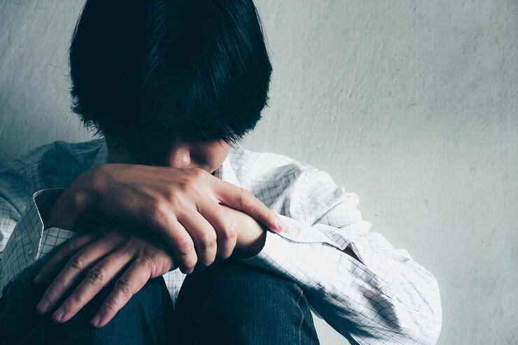 Photo 壁に寄りかかって座っている悲しい男