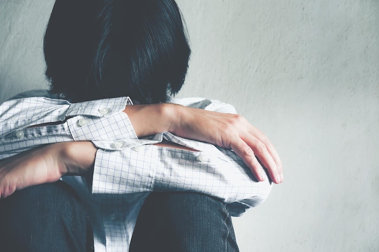 Photo 壁に寄りかかって座っている悲しい男