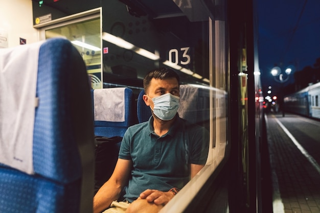 슬픈 남자는 기차에서 보호 마스크를 착용