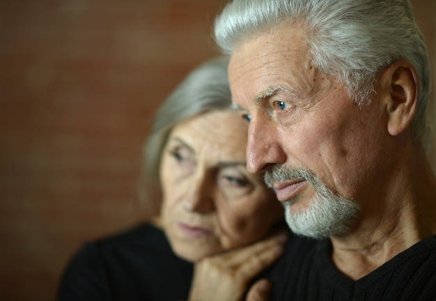 Sad Mature couple near wall in the room
