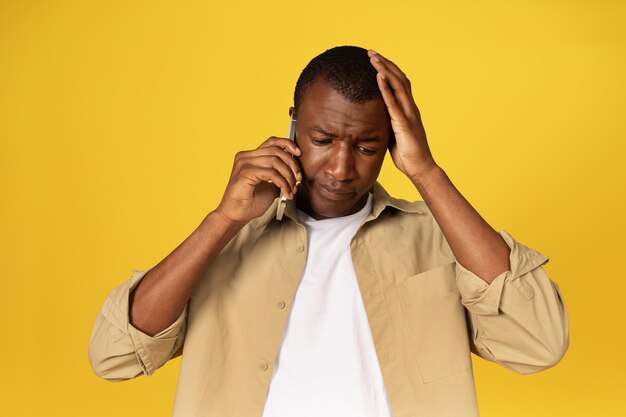 Sad millennial black guy in casual call on phone talk suffer from mistake