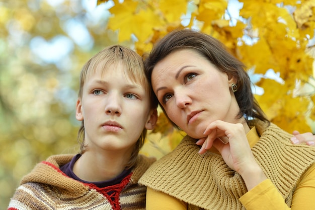 Sad mother with a son in the autumn park