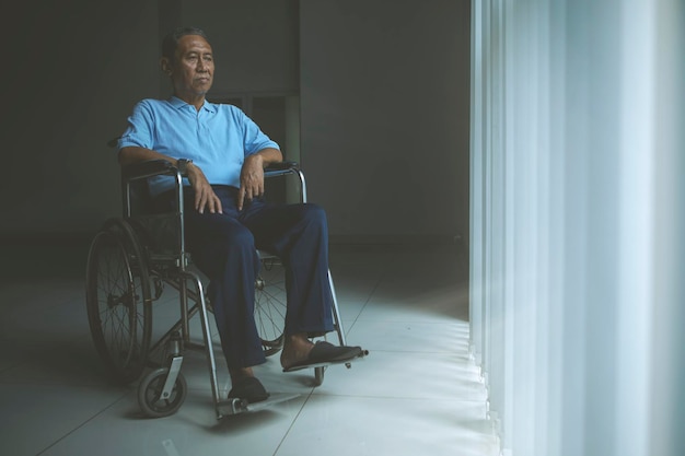Sad old man sitting in a wheelchair
