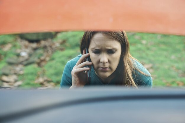 写真 悲しいか怒った美しい女性が保険や牽引車に電話する