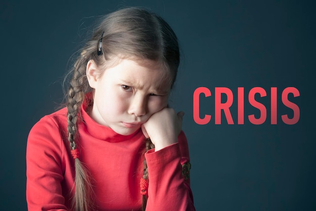 Sad pensive girl with pigtails and with the inscription Crisis