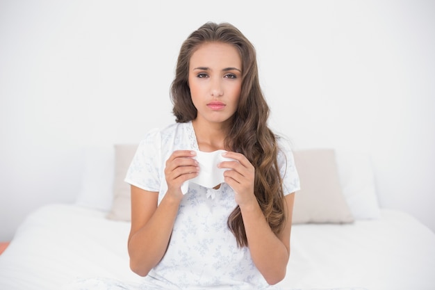 Sad pretty brunette holding a tissue