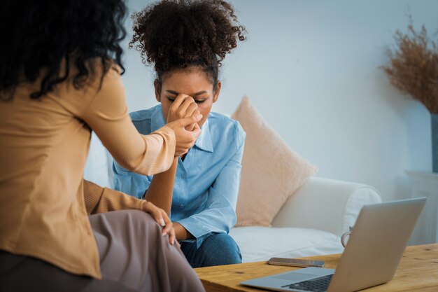 Sad PTSD woman patient in crucial therapy for mental health with psychologist depression or grief after life failure Frustrated trauma young woman talking to a psychologist about emotion in clinic