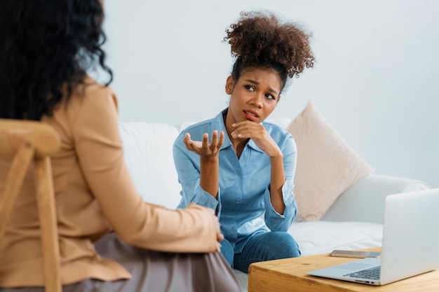 Photo sad ptsd woman patient in crucial therapy for mental health with psychologist depression or grief after life failure frustrated trauma young woman talking to a psychologist about emotion in clinic