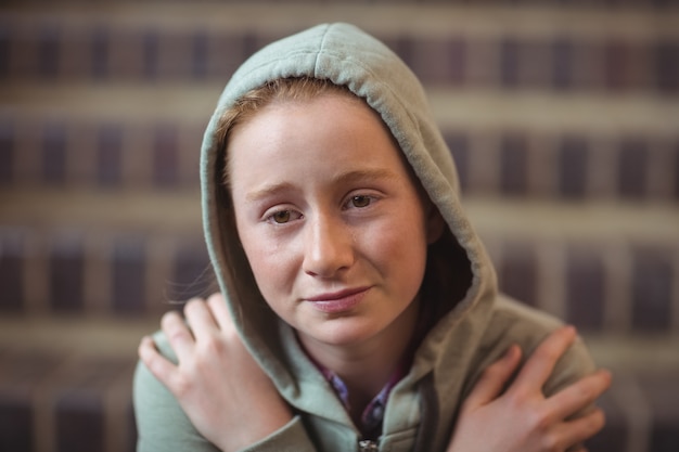 Sad schoolgirl sitting alone on staircase