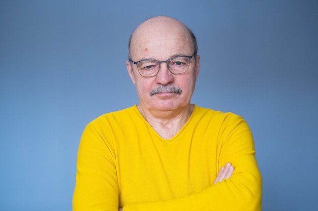 Sad senior hispanic man in glasses looking down being alone