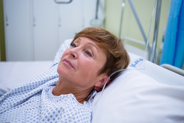 Sad senior patient lying on a bed