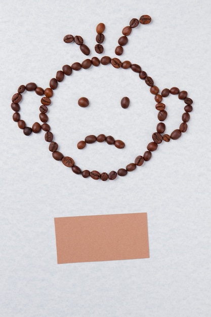 白で隔離されるコーヒー豆から悲しい笑顔の少年の顔