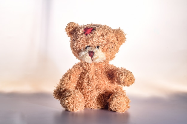 sad teddy bear isolated on white wall