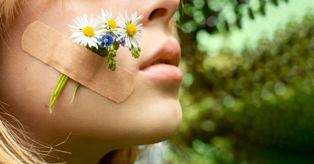 Sad teen girl with flowers glued with plaster on her cheek