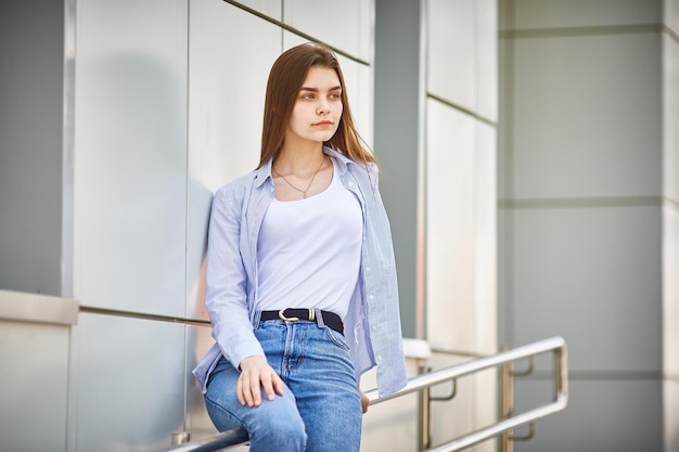 Sad teen girl with sitting on the railing of a building Psychological problems of teenagers