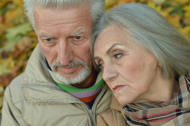 Sad thoughtful senior couple in park