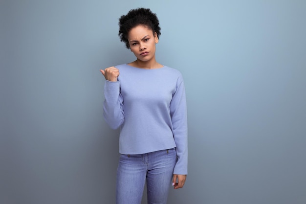 Sad tired young latino s woman with black hair in a bun shows the idea with her finger