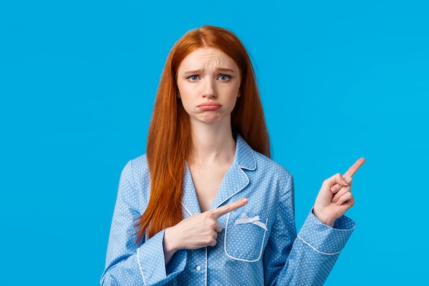 Sad unhappy redhead woman in nightwear